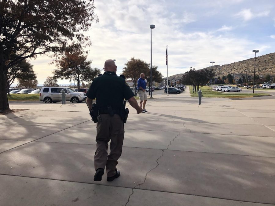Dave Bruening, SRO officer at Dakota, meeting with another security member outside of Dakota Ridge High School. Both men were relaxed when speaking with fellow coworkers, calmly taking care of the situation at hand. 
	
