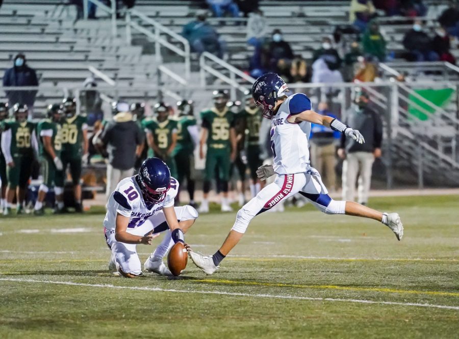 Dakota senior wide receiver/kicker Max Hart aims to kick the ball held by senior wide receiver Mason Galbreath, pursuing the field goal that will aid the team in their victory.