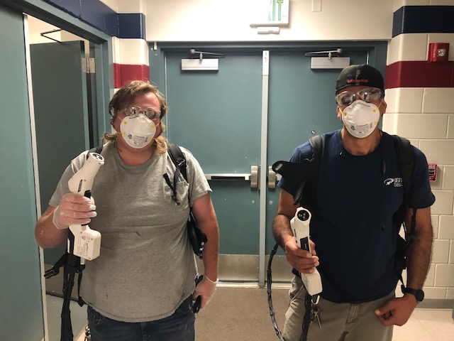 Custodians Sam Faus III (left) and Beau Dorval (right) show off their tools to disinfect the school