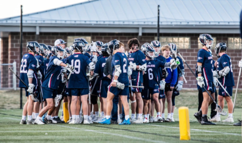Dakota Ridge Mens Lacrosse team gathers in the end zone to review game plan and yell a team chant.  