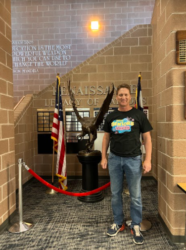 The one and only Dr. Jim Jelinek poses next to the statue of an eagle in the DRHS main hall. He is wearing the t-shirt created for the graduating class of 2022 on their last school day, May 13, 2022. 