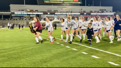 Senior captain Kassidy Spencer carries the State Championship trophy to the fans after a 2-0 win against Lutheran.