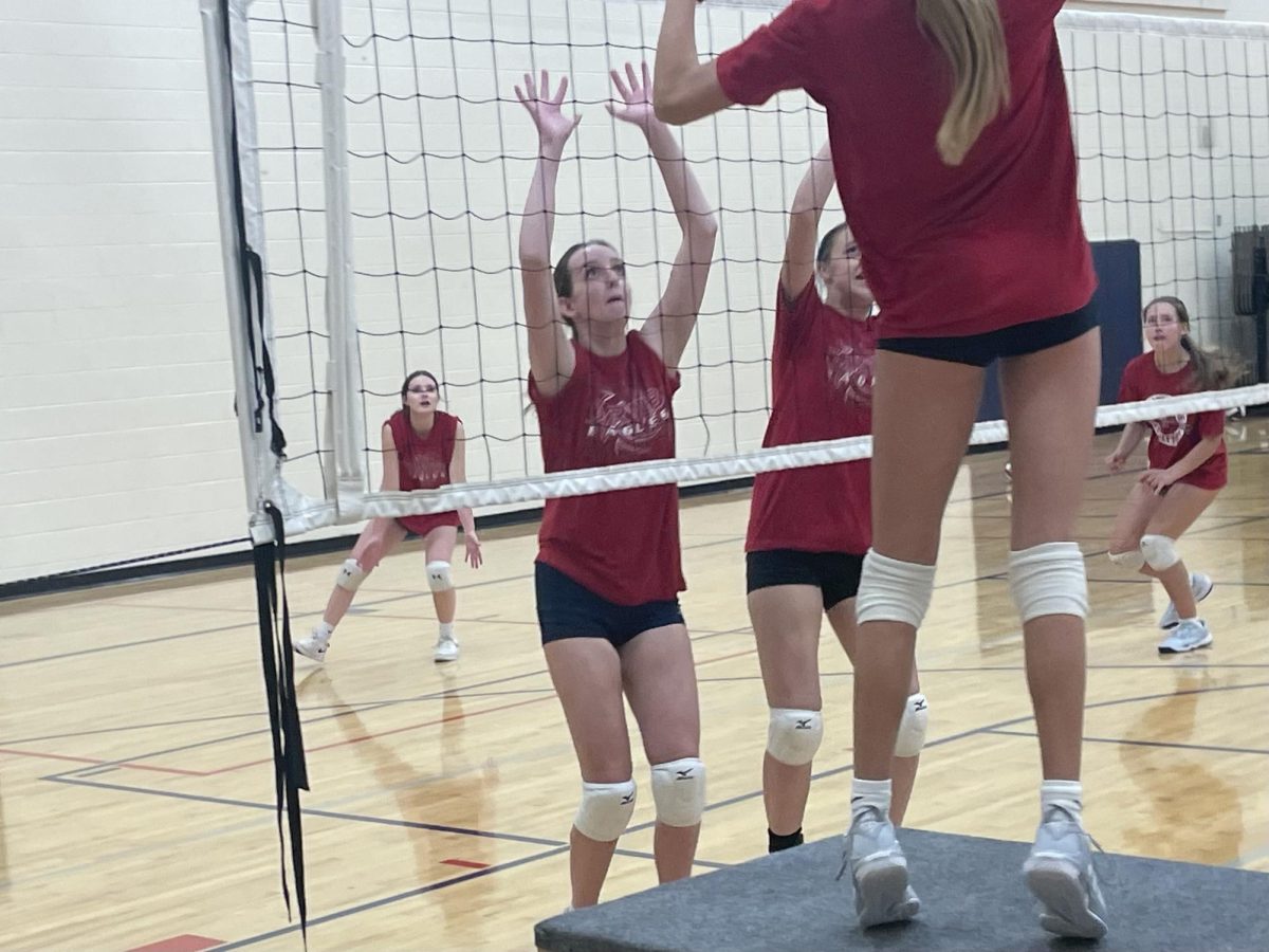 Riley Henry working hard in practice using her height to make sure no spikes get past the net.
