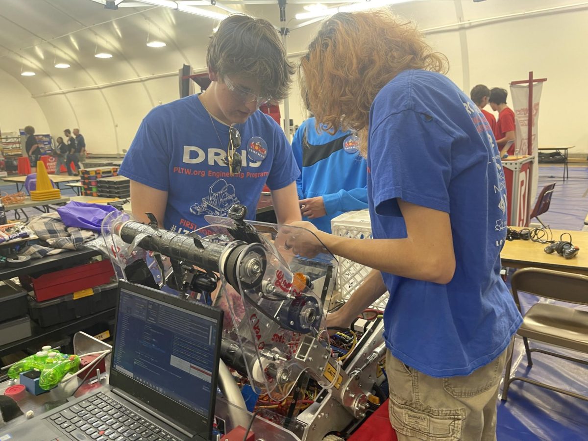 Jace Johnson (right) and other team members configure a team robot.