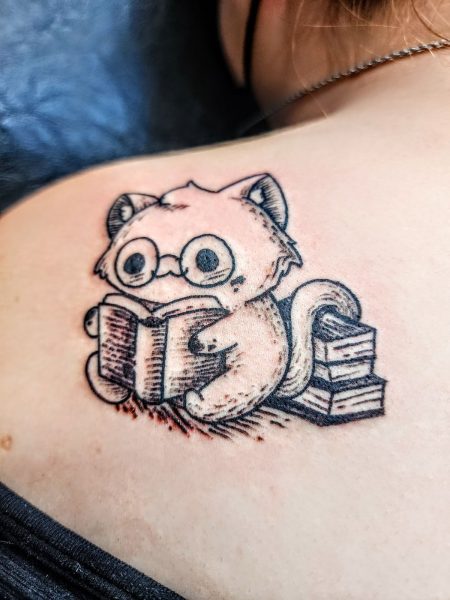 My first tattoo is on the back of my left shoulder. I got it to match with my mom, who has a cat as a mechanic. I’m the booknerd and writer of the family, while she’s the car nerd, and since we both love cats, it just seemed fitting.